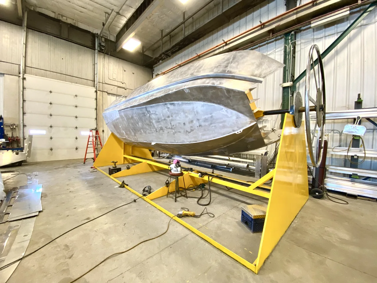 An unfinished boat hull set on a fabrication stand