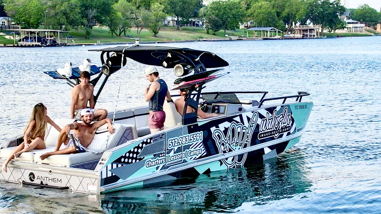People aboard an Anthem boat with a watersports-school wrap on the lake