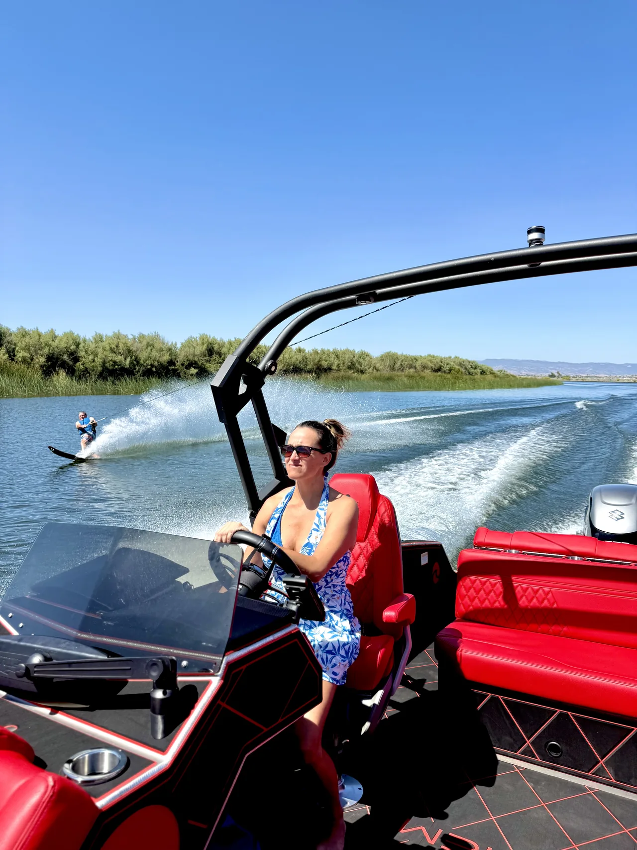 At the Assault VF23 helm with a waterskier behind the boat